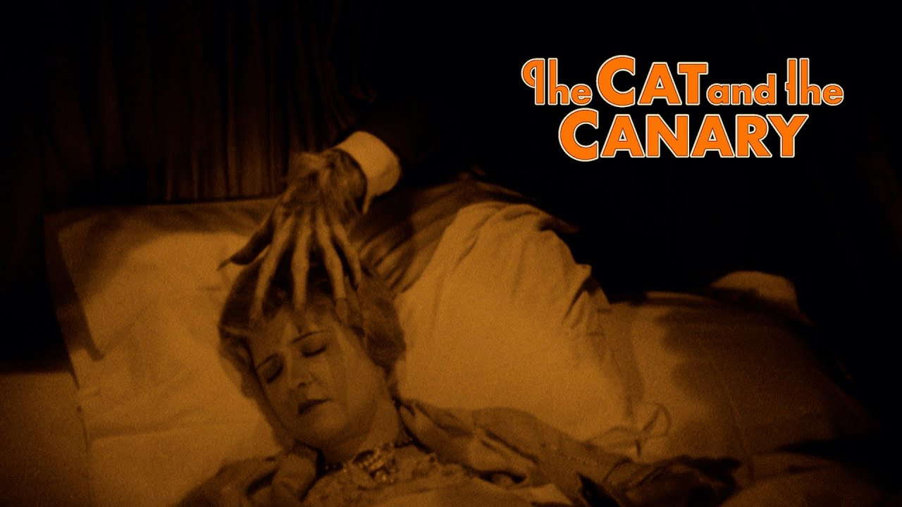 A hand creepily reaches for the necklace worn by Annabelle